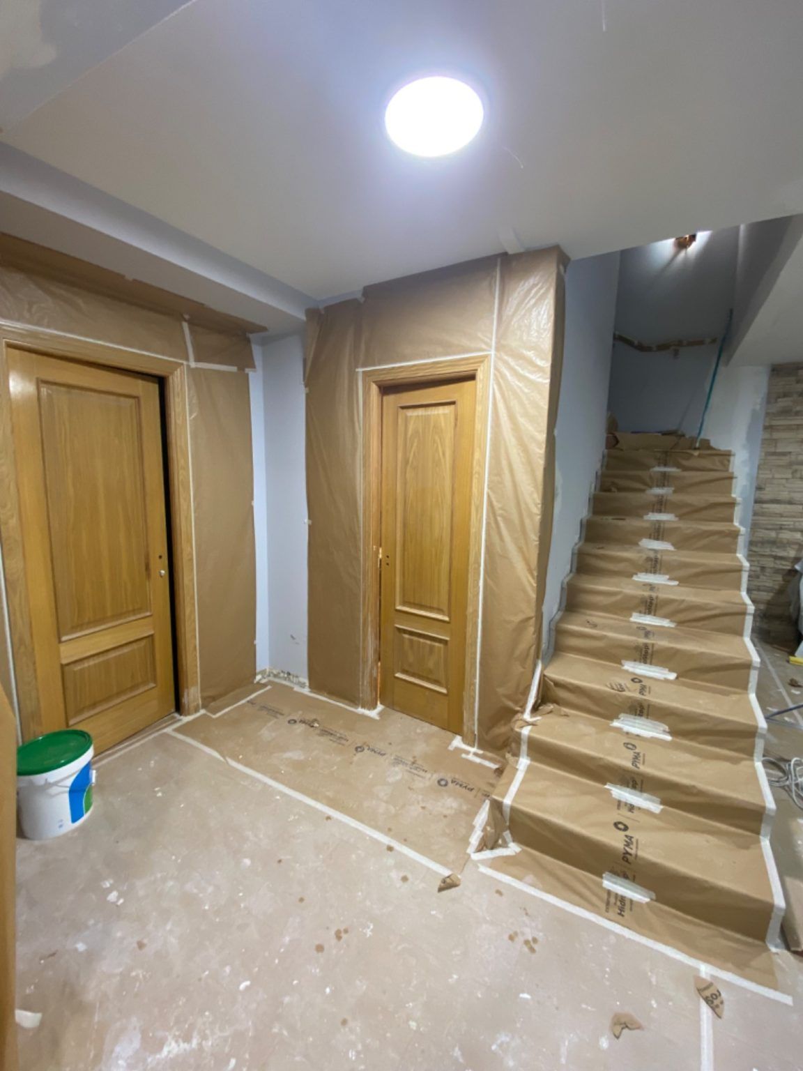 Pasillo con escaleras antes de la reforma, paredes y puertas en madera